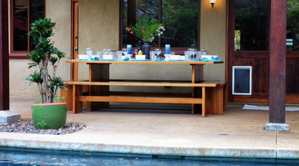 The long teak table and benches beside the pool at Casa Colorado, a vacation rental home with a private pool in Tamarindo, Costa Rica