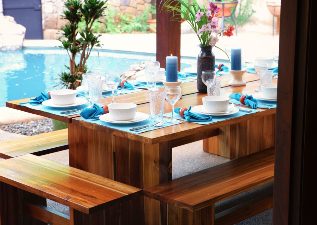 Dinner set on the teak table by the pool at Casa Colorado, a vacation rental home with a private pool in Tamarindo, Costa Rica