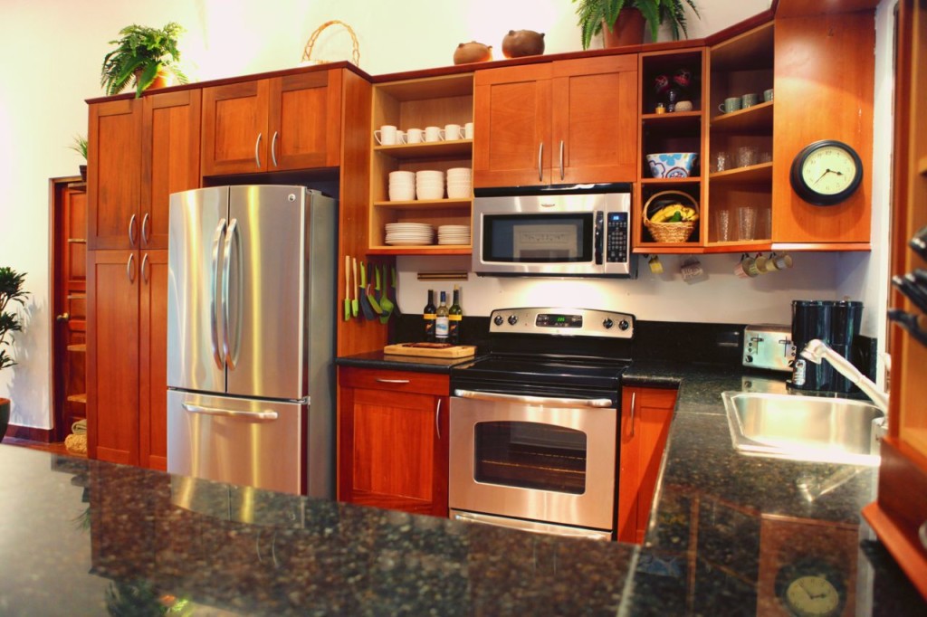 Wood cabinets, range and microwave at Casa Colorado, a vacation rental home with a private pool in Tamarindo, Costa Rica