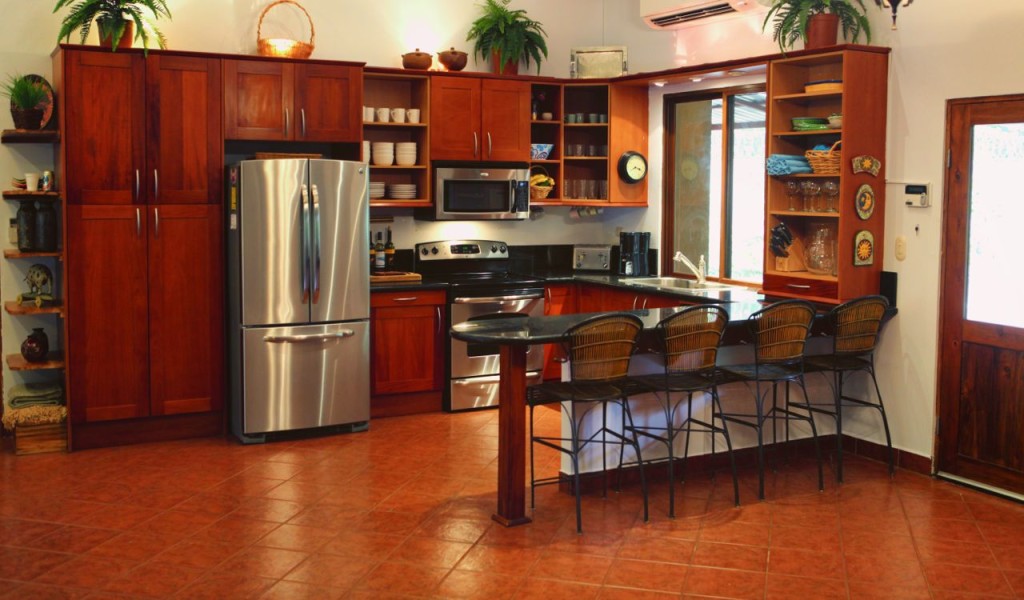 The kitchen and breakfast bar with a stainless refrigerator at Casa Colorado, a vacation rental home with a private pool in Tamarindo, Costa Rica
