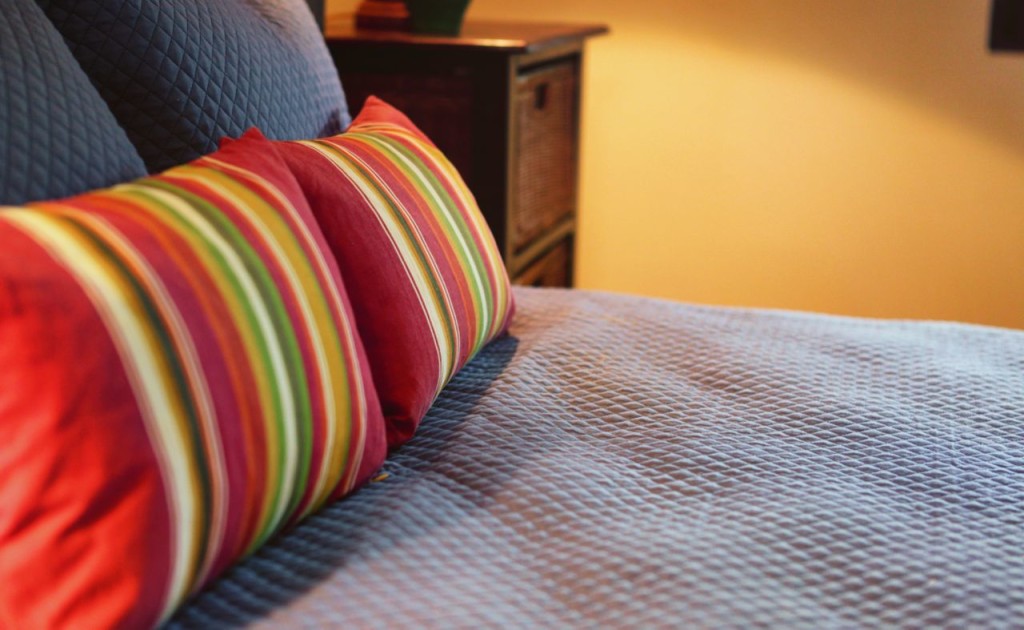Striped pillows on the queen bed at Casa Colorado, a vacation rental home with a private pool in Tamarindo, Costa Rica