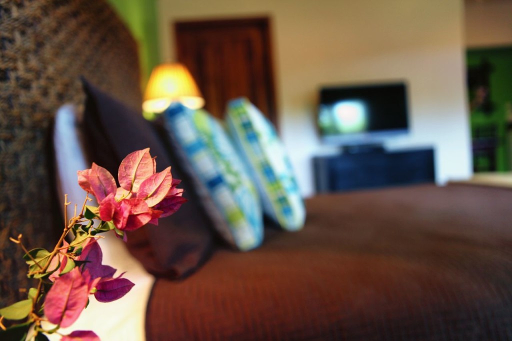 The casita bed with an orchid in the foreground at Casa Colorado, a vacation rental home with a private pool in Tamarindo, Costa Rica