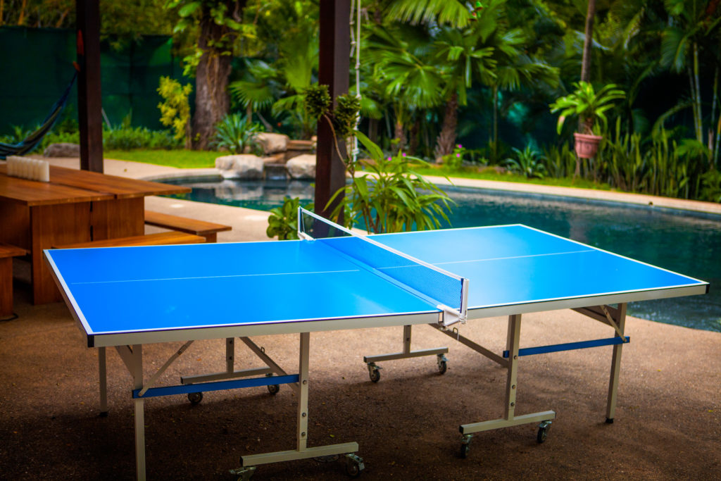 Outdoor ping pong table on the pool deck under the trees at Casa Colorado, a vacation rental home with a private pool in Tamarindo, Costa Rica