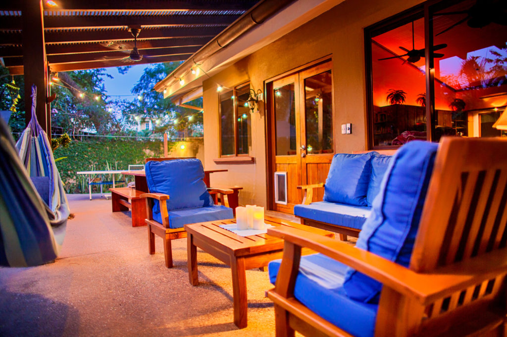 Teak sofa and chairs with blue cushions on the covered patio at Casa Colorado, a vacation rental home with a private pool in Tamarindo, Costa Rica